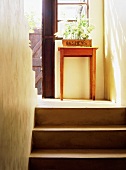 Ein alter Beistelltisch aus Holz in einem schlichten Treppenaufgang