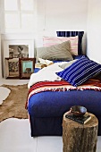Ein Schlafzimmer mit blauem Tagesbett und antik-rustikaler Deko