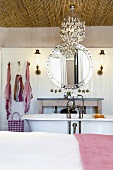 Eine Deckenverkleidung aus Bambusstäben bildet einen spannenden Kontrast zur romantischen Vintageeinrichtung des Badezimmers