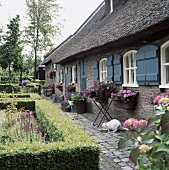 Ein traditionell nordfriesisches Backsteinhaus mit Reetdach und blauen Fensterläden