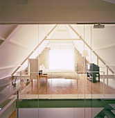 Glasschiebewände trennen den puristischen Schlafbereich im Dachgeschoss vom Badezimmer
