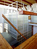 Ein moderner Glaseinbau, der sich vom Erdgeschoss bis zur Galerie erstreckt