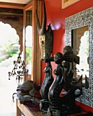 Ethnoskulpturen aus Holz vor einer roten Wand
