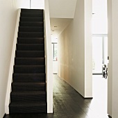 Ein weisser Treppenraum mit schwarzer Treppe