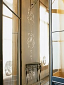 Ein filigraner Wandtisch mit feiner Ornamentik, die sich an der Wand fortsetzt