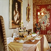 Gedeckter Esstisch mit Seidentischdecke im prunkvollen Esszimmer mit Wandteppich und Barockgemälden