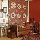 Antike Dekoelemente komplettieren das Vintagefeeling des gemütlichen Wohnzimmers mit alter Ledercoch und großem Wandteppich