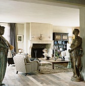 Griechische Statuen im großen, stilgemixten Wohnzimmer mit altem Holzcouchtisch und antikem Buffetschrank
