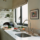 Ausschnitt einer Küchenzeile mit Marmoroberfläche und eleganter Spülarmatur