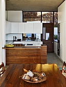 Designerküche und Esszimmer mit hochwertigen Holzoberflächen in moderner Beton- und Glasarchitektur