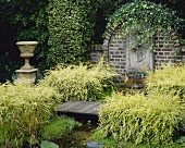 Wall fountain and small pond overgrown with lonicera