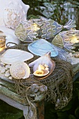 Maritime summer decoration: shells & tealights in fish-shaped holders