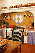 Ländliche Küche mit gefliester Küchenzeile, Wandregal mit Vorräten & rustikalem Holztisch