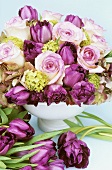 Arrangement of pink roses and purple tulips