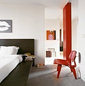Moderner offener Schlafraum mit Bett, Stuhl & Wandbildern