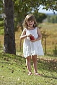 A little girl holding an apple