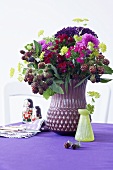 An autumnal bouquet in a purple vase