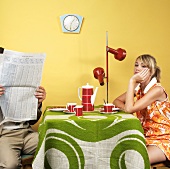 Young couple with coffee and newspaper