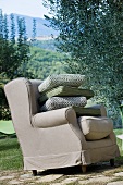 Armchair with pile of cushions in garden