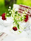 Vase mit Frühlingsblumen auf einem Tisch im Garten