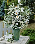 Vase of white flowers out of doors