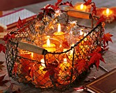 Windlights in wire basket decorated with maple leaves