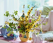 Vase of forsythia and bird cherry with porcelain bells