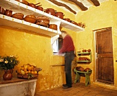 Mann spült Geschirr in ländlicher Küche