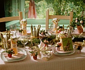 A spring table laid with asparagus and daisies