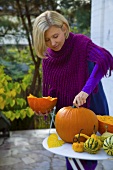 A woman on a terrace with pumpkins