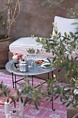 A Moroccan living room with a pot of tea, glasses and sweets on a table