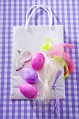 Easter eggs, Easter Bunny biscuit, feathers on paper carrier bag