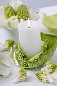 Winter table decoration: candle, savoy cabbage and romanesco
