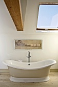 Free-standing bathtub on wooden floor
