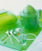 An electric citrus press on a green glass tray