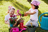 Zwei Mädchen mit Blumen im Garten
