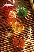 Bunte Cocktailschirmchen und Spiesschen auf Bambustablett