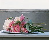 A bunch of pink peonies in a bowl
