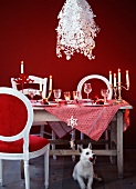 A table laid for Christmas dinner with designer lamps and a dog in the foreground