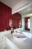 A red-tiled wall in a bathroom with a view of the basin