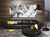 A black leather sofa and a coffee table with a floor lamp in front of a wood panelled partition wall with a photo hung on it