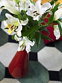 weiße Lilien in roter Vase