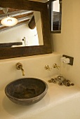 Rustikaler Waschbereich mit Waschschüssel, Messingwandarmatur und Spiegel
