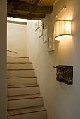 Wall lighting in a stairwell with brick staircase