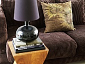 Brown corduroy sofa with pillows and side table with table lamp