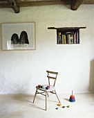 Colorful wooden blocks on an old wooden chair, a throwing game, books in a wall niche and a picture on the wall