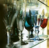 Various glasses on a glass shelf