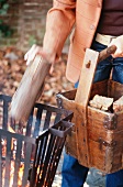 A man adding wood to a fire