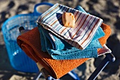 Soap and a pile of towels on a beach stool