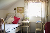 Attic room in a country house with single bed and white night stand